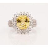 A platinum, yellow sapphire and diamond cluster ring, claw set with the octagon scissors cut...