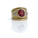 An 18ct gold, red spinel and diamond ring, collet set with the oval cut red spinel to the...