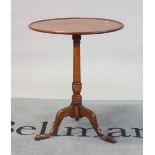 A George III mahogany tripod table with dished top on downswept supports