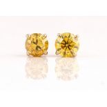 A pair of gold and natural fancy vivid orangey/yellow diamond single stone earstuds, the...