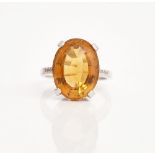 An 18ct white gold, citrine and diamond ring, claw set with the oval cut citrine between...