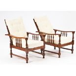 A pair of mid-20th century stained beech framed reclining open armchairs on block and turned...