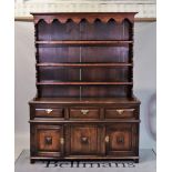 A late 19th century oak dresser with three tier plate rack over three frieze drawers and...