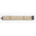 A four row bracelet of cultured pearls, on a white gold, diamond and pale blue gemstone set...