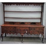 A George III oak dresser, the open back with four small drawers, the base with a deep drawer...