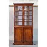 An early Victorian mahogany bookcase cabinet on plinth base