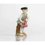 A Meissen figure of a boy gardener, late 19th century, modelled standing before a tree stump...