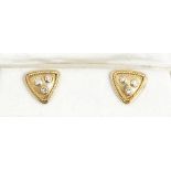 A pair of gold and diamond earstuds, each of triangular form, mounted with two circular cut...