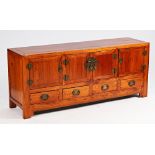 An early 20th century Chinese hardwood low cabinet with four cupboards over drawers on bracket...