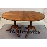 A modern mahogany and yew wood banded 'D' end extending dining table on baluster column and...