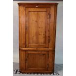 An early 20th century pine floorstanding corner cupboard