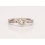 An 18ct white gold and diamond ring, claw set with the principal circular cut diamond between...