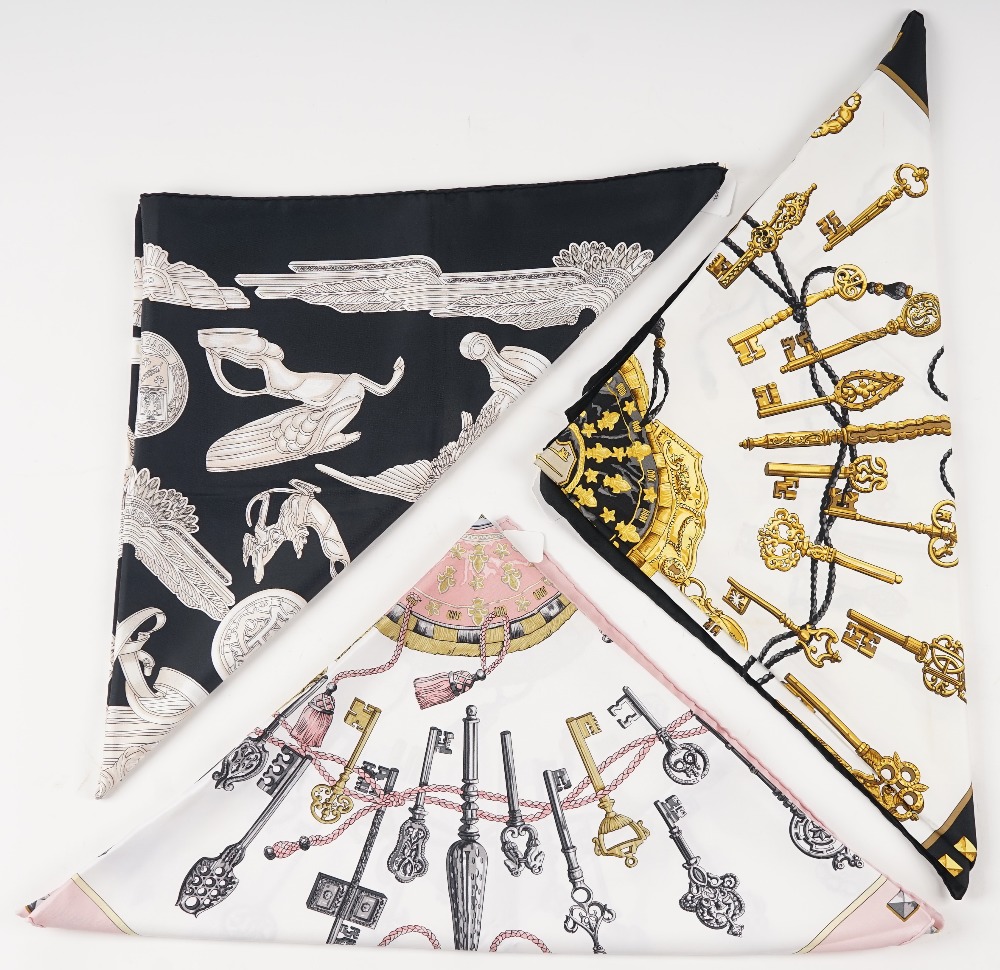 A collection of three Hermes print silk scarves, comprising: a 'Les Parure du Vent' designed...