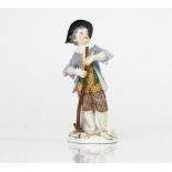 A Meissen figure of a boy gardener, circa 1900, modelled standing standing before a tree stump...