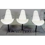 In the manner of Arne Jacobson, a set of three cream leather upholstered dining chairs