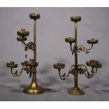 A pair of early 20th century brass six branch candlesticks on circular bases, 58cm high