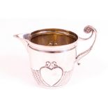 A late Victorian silver milk jug, with a foliate capped scrolling handle and decorated with...