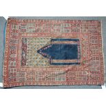 An antique Ghiordes prayer rug, Turkish, the plain indigo mehrab with two columns, a flower...