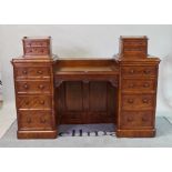 A Victorian mahogany writing desk with inset leather top flanked by eight graduated drawers on...