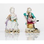 A pair of Meissen figures of children, late 19th century, modelled as a boy seated reading and...