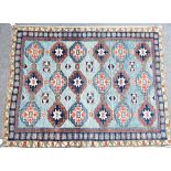 A Caucasian rug, the pale indigo field with three columns of six guls, supporting motifs; an...