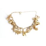 A 9ct gold charm bracelet, fitted with twelve mostly 9ct gold charms, including a ballerina, a...