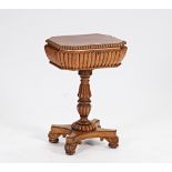 In the manner of Gillows; a Regency rosewood teapoy with twin lidded interior on reeded column...