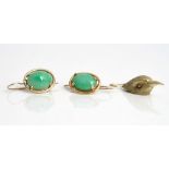 A pair of jade earrings, each claw set with an oval jade and a single earring, designed as a...