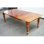 An early Victorian mahogany extending dining table, on lappet carved turned supports, with...
