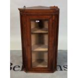 A small walnut hanging corner cabinet with glazed door