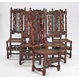 A set of six 17th century style carved oak and cane dining chairs with carved figural crests...