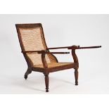 A 19th century carved hardwood cane plantation chair, 70cm wide x 90cm high.