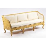 A 18th century Gustavian yellow painted square back sofa with downswept arms on seven scroll...