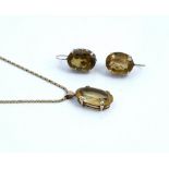 A gold pendant, claw set with an oval cut citrine, detailed 9 CT, with a 9ct gold neckchain,...