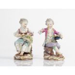 A pair of Meissen figures of a seated chidren, late 19th century, modelled as a boy seated on...