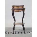 A Continental walnut and ebonised jardinere stand with shaped legs united by undertier