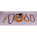 A composite amber bead necklace, four carved beaded necklaces and an agate pestle and mortar (6)