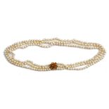 A three row necklace of cultured pearls, on a gold and citrine set seven stone cluster clasp,...