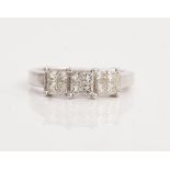 An 18ct white gold and diamond ring, designed as a row of three four stone square clusters,...