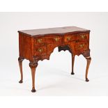 An 18th century style figured walnut serpentine lowboy, with four frieze drawers on cabriole...