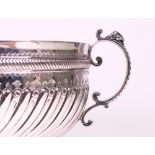 A late Victorian silver twin handled punch bowl, with spiral fluted decoration below a...