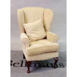 A modern hardwood framed wingback armchair