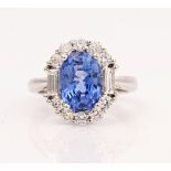 An 18ct white gold, sapphire and diamond oval cluster ring, claw set with the oval cut...