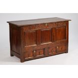 A 17th century oak mule chest the lift top over triple panel front and a pair of drawers,...