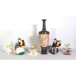 A Royal Doulton tall baluster vase, painted and gilded with flowers against a biscuit ground,...