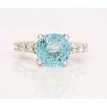 An 18ct white gold, paraiba tourmaline and diamond ring, claw set with the cushion cut paraiba...