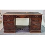 A late 19th century oak pedestal desk with inset leather top over nine drawers about the knee.