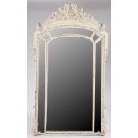 A white painted Louis XVI style wall mirror with flaming torch and quiver crest above the...