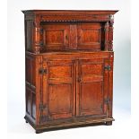 A 17th century oak court cupboard with two pairs of panelled doors and turned supports, 123cm...
