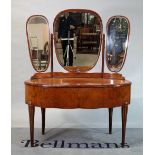 An early 20th century walnut oval dressing table with tryptich mirror back